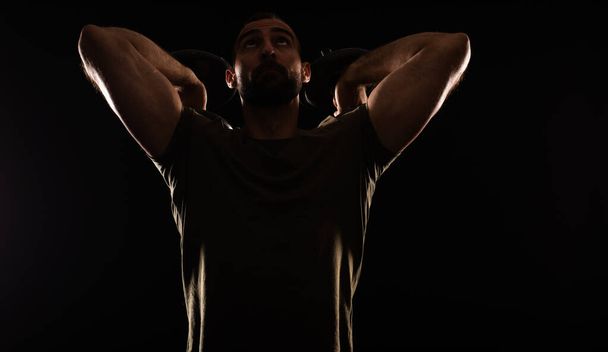 Portrét pohledného chlapa cvičícího s váhou zezadu při soustředění na cvičení - Fotografie, Obrázek