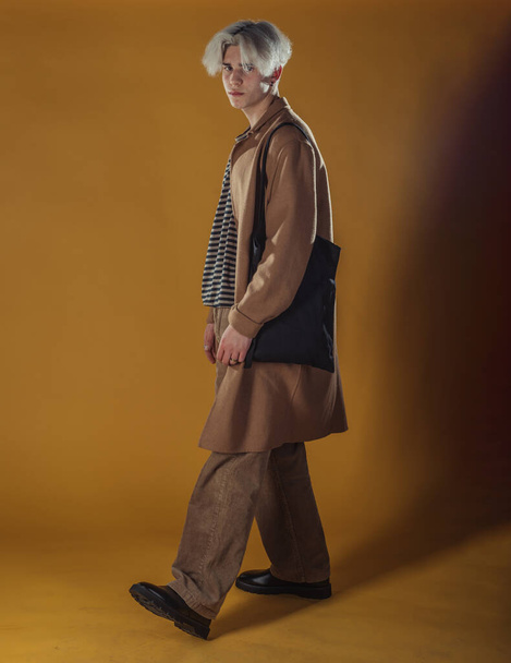 Portrét chytrého mladého muže stojícího proti žlutému pozadí - Fotografie, Obrázek