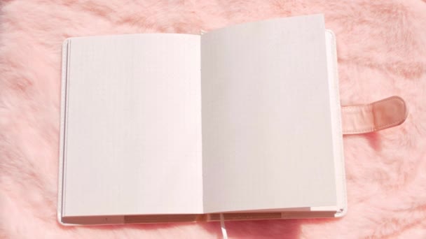 Cuaderno en blanco maqueta de piel de imitación rosa plana laico. Coral esponjosa tela femenina fondo vista superior. blog femenino rosa superficie textil bloc de notas copia espacio texto signo de diseño. Plantilla de hoja de cuaderno blanco - Metraje, vídeo
