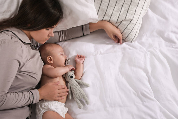 Mother and baby sleeping on bed together, top view. Space for text - Foto, Imagem