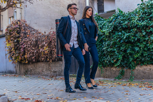 スタイリッシュなビジネスマンと女性がオフィスに向かって歩く - 写真・画像