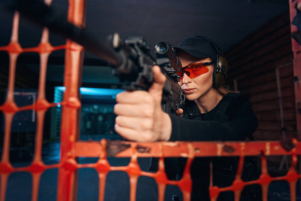 Cecchino donna con esperienza che spara a un bersaglio al chiuso - Foto, immagini