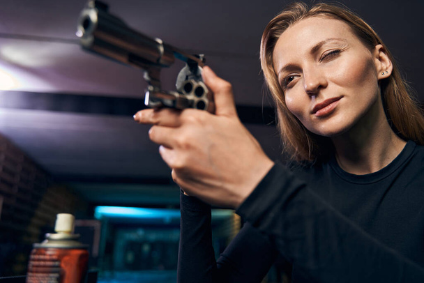 Serena signora che punta la pistola contro un bersaglio - Foto, immagini