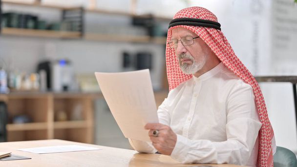 Antiguo empresario árabe leyendo documentos en el trabajo  - Foto, Imagen