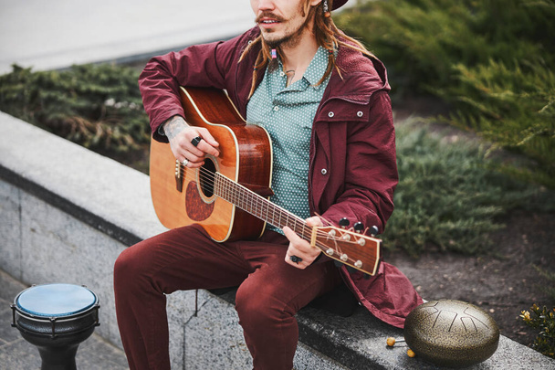 Крупный план молодого человека, играющего на гитаре - Фото, изображение