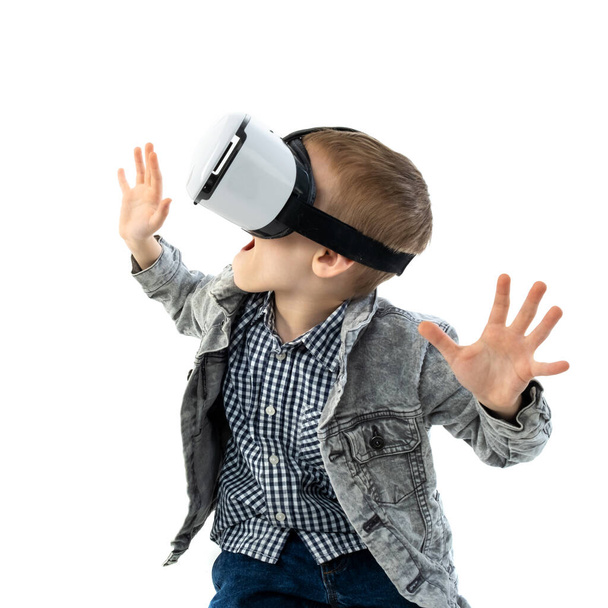 Young boy with virtual reality glasses isolated on white background. A child in emotional excitement wearing 3D glasses. - Foto, imagen