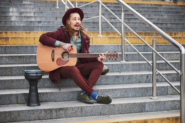 Hombre alegre con rastas tocando música al aire libre - Foto, Imagen