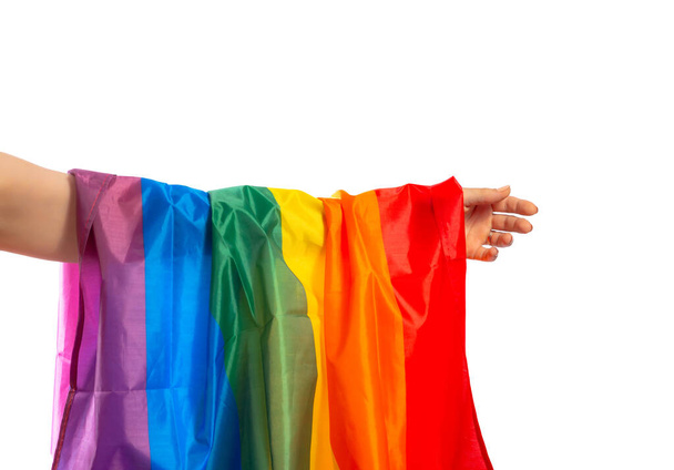Flaga LGBT w kobiecej dłoni odizolowana na białym tle. - Zdjęcie, obraz
