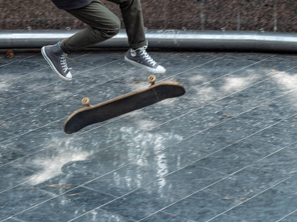 Vrijetijdsbesteding. Sportieve levensstijl. Jonge skateboarder springt in het publieke park. Extreme sporten is erg populair onder de jeugd.  - Foto, afbeelding