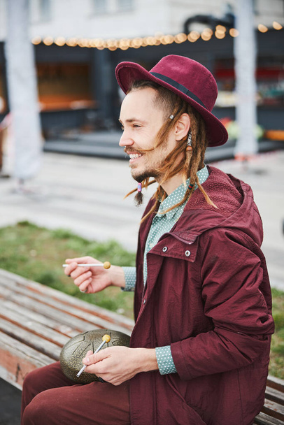 Entzückte männliche Person, die die stählerne Zungentrommel spielt - Foto, Bild