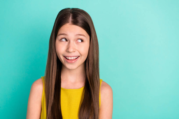 Photo of optimistic nice brown hair girl look empty space wear yellow dress isolated on bright teal color background - Photo, image