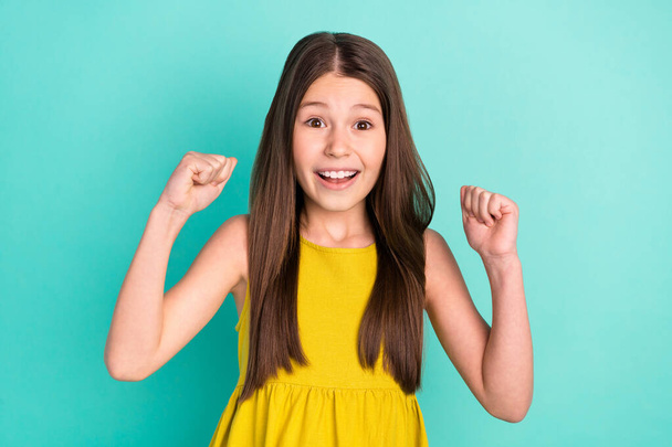 Photo of hooray nice brown hair girl hands fists wear yellow dress isolated on bright teal color background - Foto, imagen