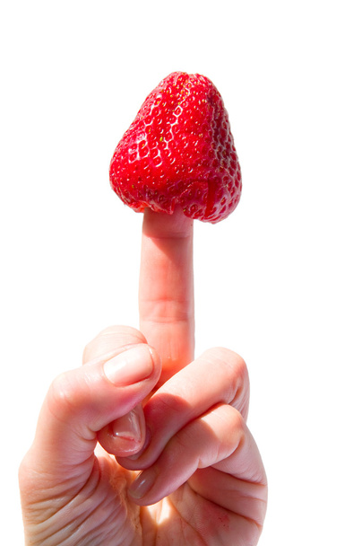 A strawberry stuck in the middle finger - Fotoğraf, Görsel