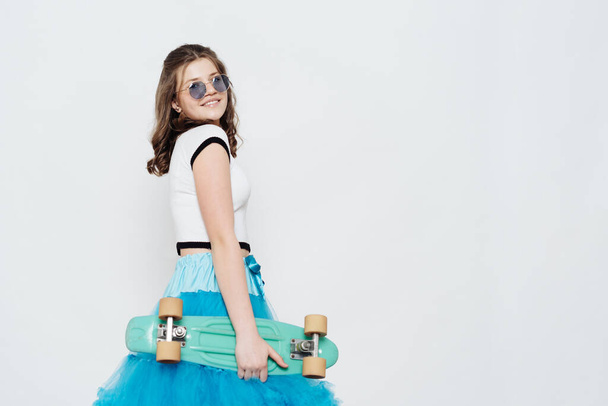 Beautiful teenager posing with penny board on white background - Photo, image