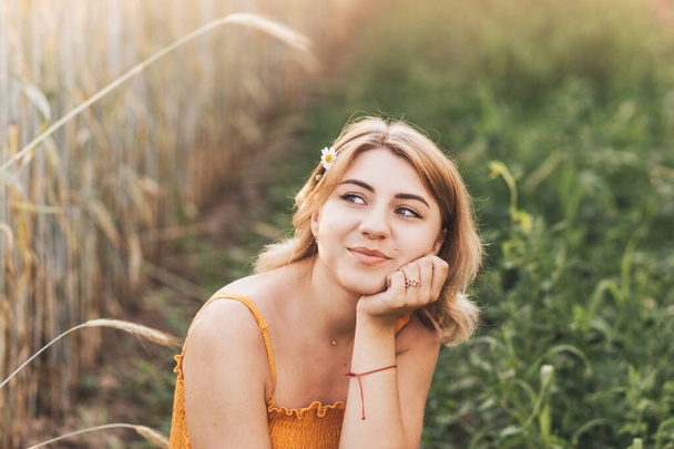 Young beautiful girl with chamomile flower in her hair - Fotoğraf, Görsel