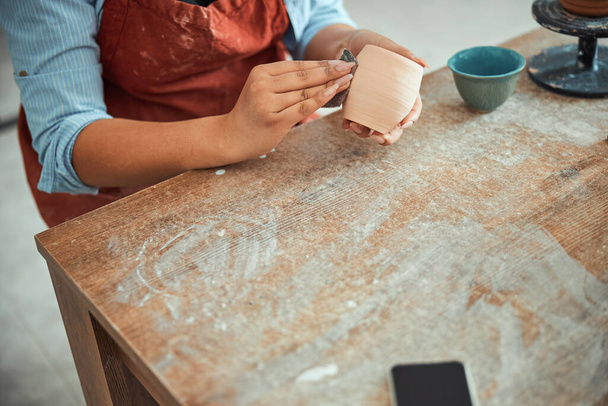 Керамические руки женщин шлифуют глиняный горшок в керамической мастерской - Фото, изображение