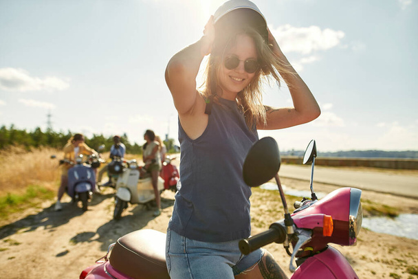 Happy young caucasian girl on scooter motorbike - Foto, afbeelding