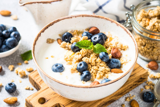 Yogurt granola with fresh blueberries on stone table. - Photo, Image