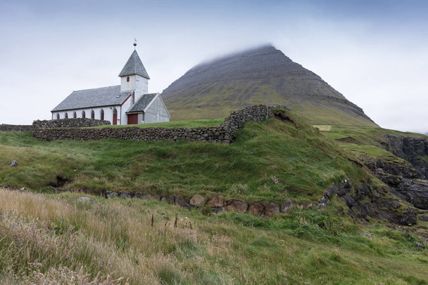 Güneşli bir yaz gününde, dağ zirveleri ve sakin denizlerle ünlü Gasadalur şelalesi. Danimarka, Avrupa 'daki Faroe Adaları' ndaki muhteşem uçurumlar. Yüksek dağ zirveleri manzarası. - Fotoğraf, Görsel
