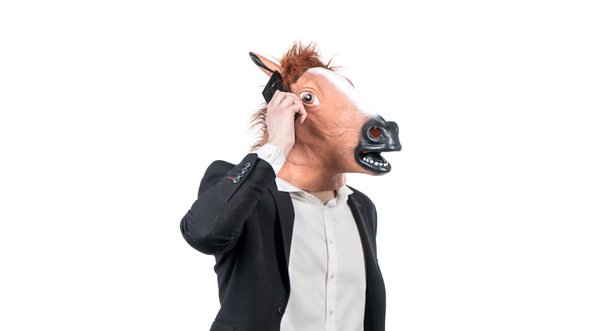 Ciężko pracujący człowiek w głowie konia rozmawiać na telefon komórkowy odizolowany na białym, komunikacji biznesowej - Zdjęcie, obraz