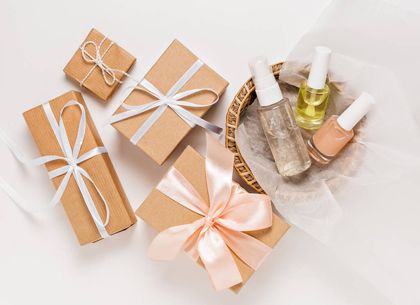 Organic cosmetics and gifts for the holiday. Flat lay, top view clear glass pump bottle, brush jar, moisturizing serum jar in a paper basket on a white background. Natural cosmetics SPA - 写真・画像