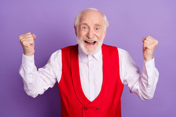 Photo of cheerful happy positive victorious man winner good mood hooray isolated on violet color background - Photo, Image