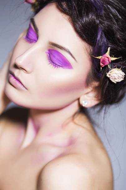 schöne brünette Frau mit kreativem Make-up und toten Rosen in Flechtfrisur - Foto, Bild