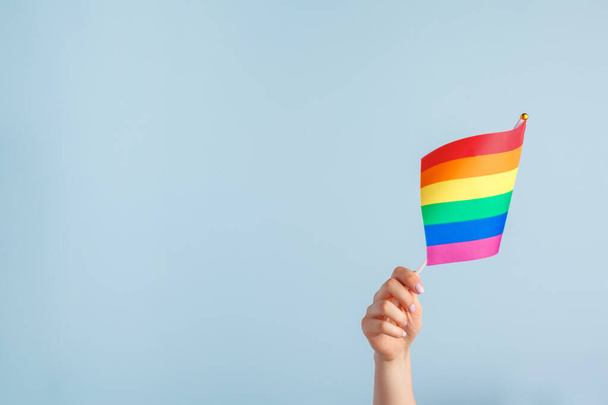 Gay flags in womens hand on grey background - Фото, зображення