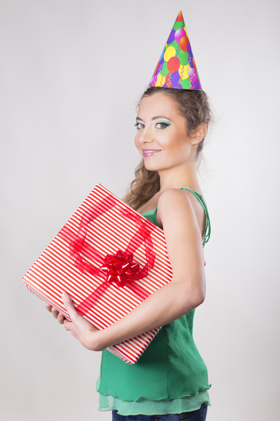 Brunette Woman in a Birthday Cap Holding Presents and Smile - Fotoğraf, Görsel