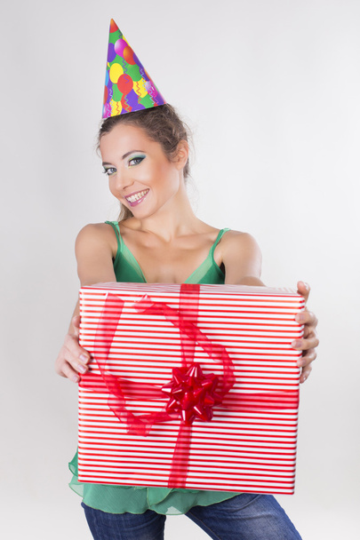 Brunette Woman in a Birthday Cap Holding Presents and Smile - Photo, Image