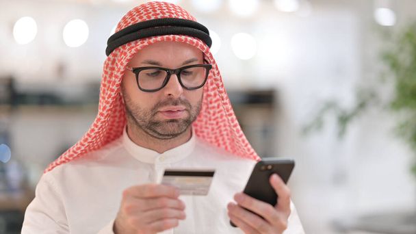 Hombre árabe joven Compras en línea en Smartphone  - Foto, imagen