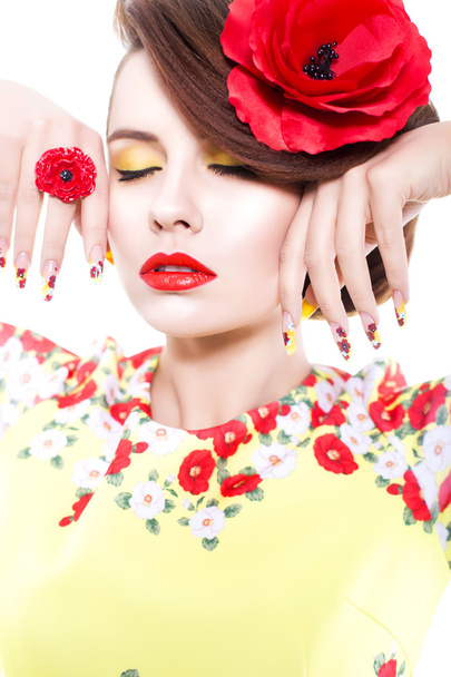 Brunette woman in yellow and red dress with poppy flower in her hair, poppy ring and creative nails, closed eyes on white background - Фото, зображення