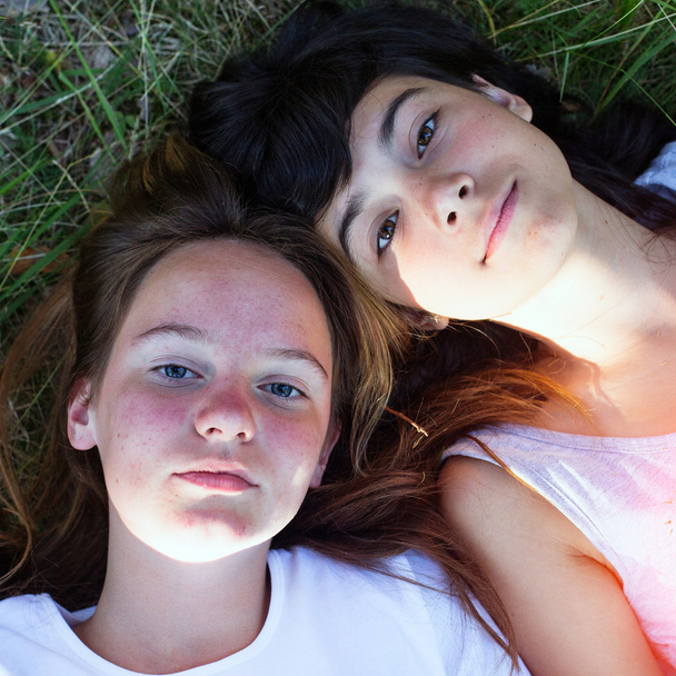 Dois jovem deitado na grama
 - Foto, Imagem