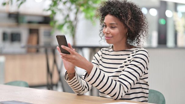 Serious African Woman Browsing Internet on Smartphone in Office - Foto, Bild