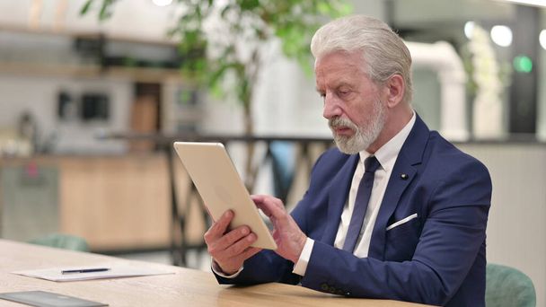Töprengő öreg üzletember használja Tablet az irodában - Fotó, kép