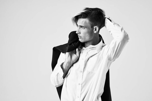 schöner Mann im weißen Hemd mit Jacke auf den Schultern modisches Friseurstudio - Foto, Bild
