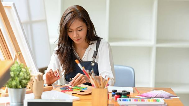 Молода азіатка насолоджується концепцією живопису, змішаним кольором на художній палітрі в художній майстерні, студентка
 - Фото, зображення