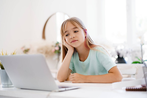 Happy little girl pupil using laptop at home - Fotografie, Obrázek