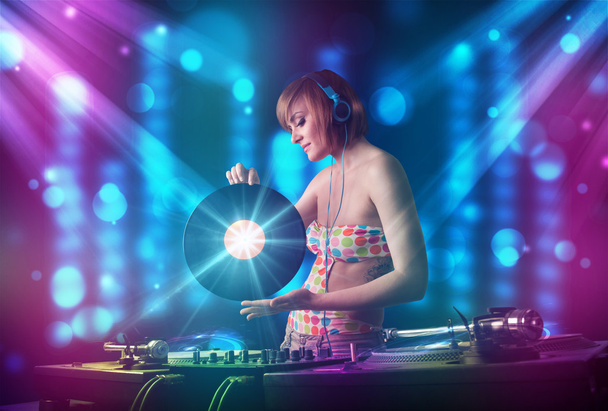 dziewczyna DJ miksowania muzyki w klubie z niebieski i fioletowy światła - Zdjęcie, obraz