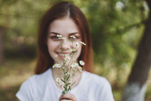 Doğada kır çiçekleriyle güzel bir kadın  - Fotoğraf, Görsel