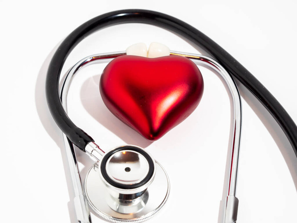 Rood hart en stethoscoop op een witte tafel. - Foto, afbeelding