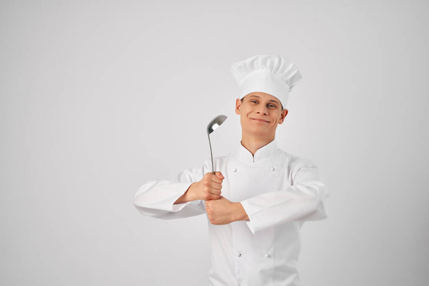 человек в форме шеф-повара с кухонной утварью - Фото, изображение