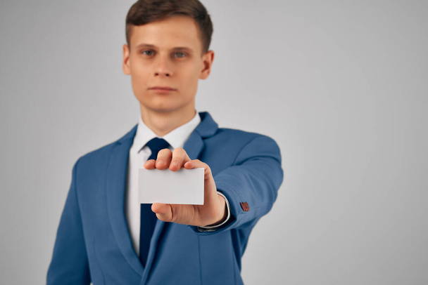 business man in a suit holding a business card with  copy space  - Фото, изображение