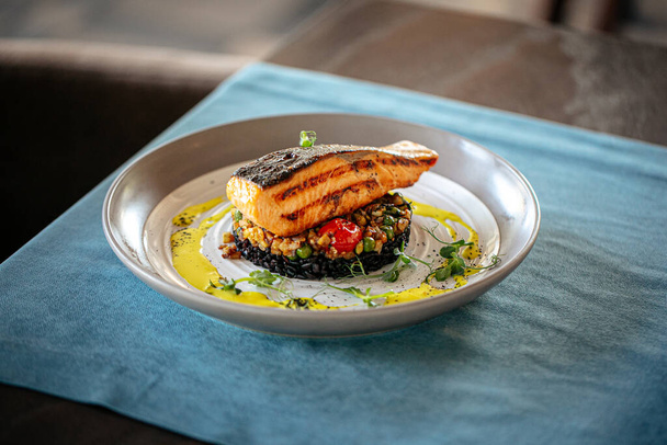 Salmon with creamy basil sauce and black rice - Foto, imagen