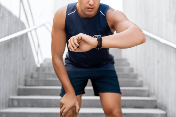 young man with fitness tracker on city street - Фото, изображение