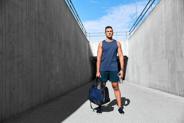 sportsman with bag and bottle walking outdoors - Foto, Bild