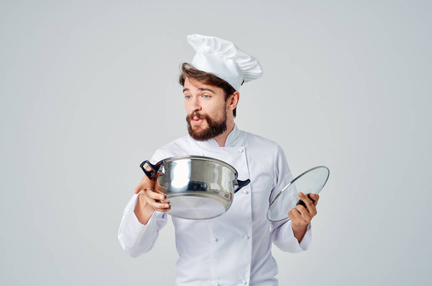 профессиональный повар с кастрюлей в руке, работающий на кухне. Высокое качество фото - Фото, изображение