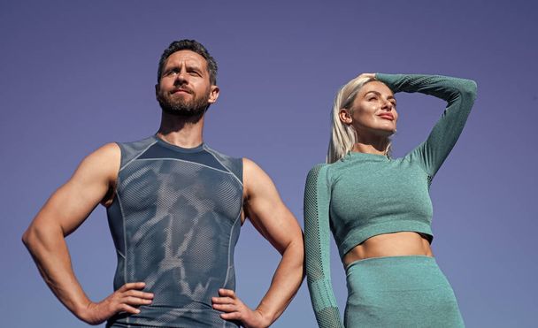 training with coach. muscular man and sexy woman in sportswear. athlete people feel success. fitness trainer coach. guy and woman relax after workout outdoor. sporty fashion. confident sport couple - Photo, Image