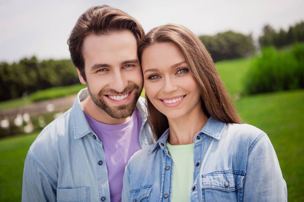 Portrait of good mood smiling couple relaxing outdoors in park countryside have romantic date outside wear denim shirt - Photo, Image