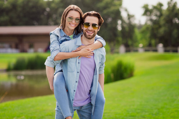 Photo of positive smiling married couple hangout together relaxing summer vacation husband hold wife piggyback - Valokuva, kuva